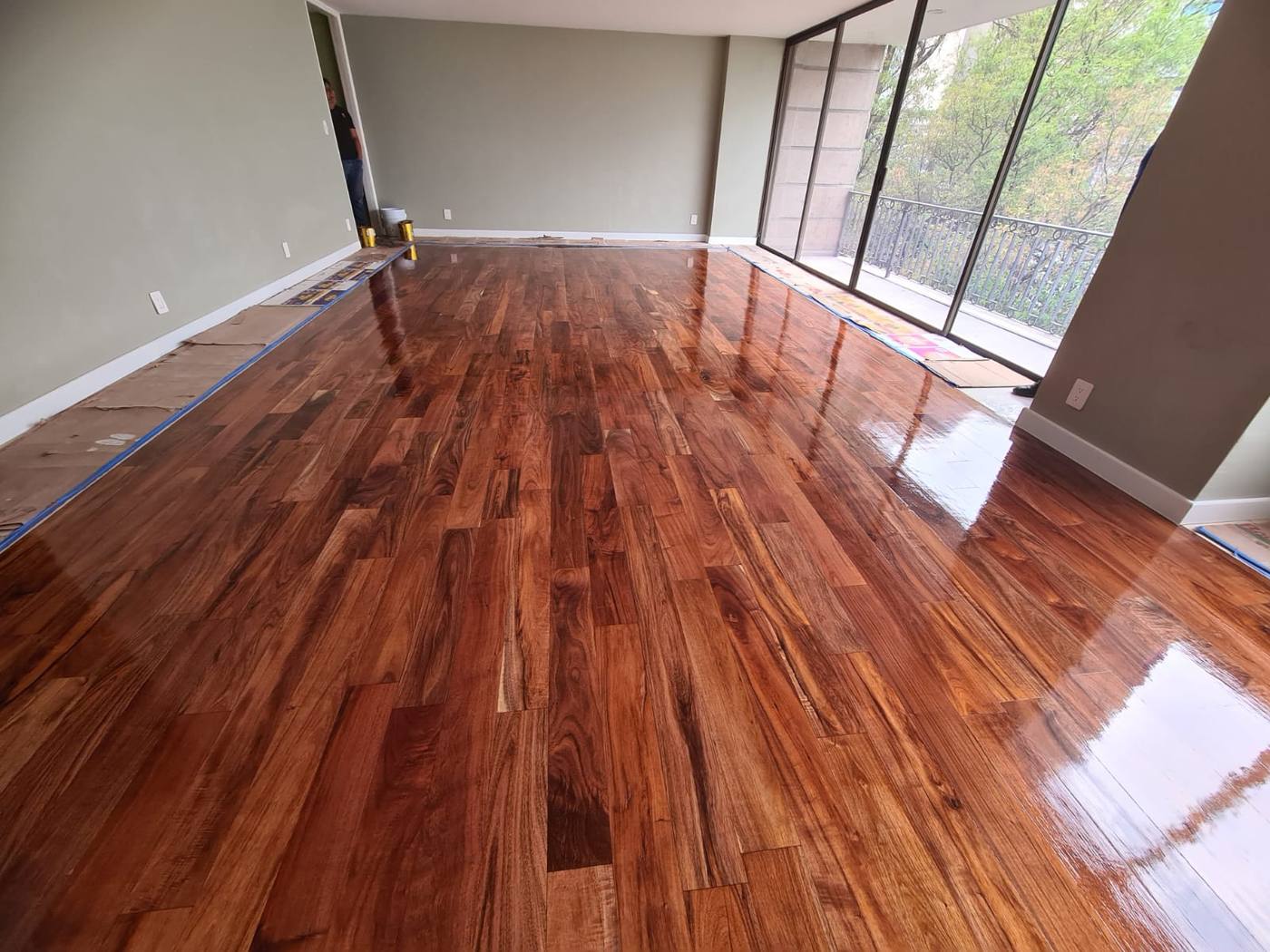 Piso de madera rojiza con grandes ventanales