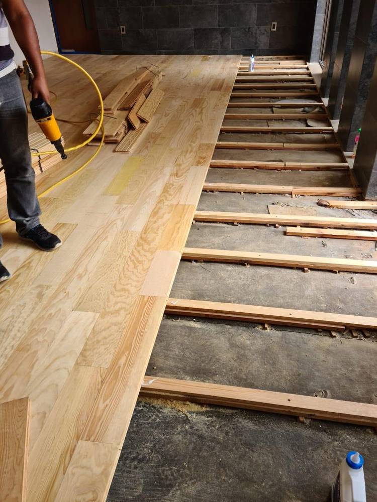 Instalando piso de madera con compresora